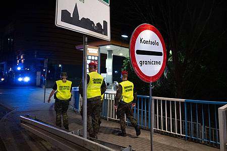 Sebastian Kahnert/dpa | Polnische Grenzschützer gehen über die Stadtbrücke von Görlitz in Richtung Polen. 