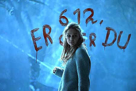 Die Protagonistin Klara steht vor einer Wand mit Datum und schaut sich verängstigt um.
