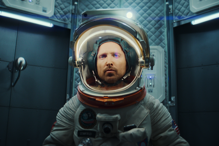 Aaron Paul in seiner Rolle als Astronaut bei Black Mirror trägt in einer engen Kapsel einen Raumanzug.