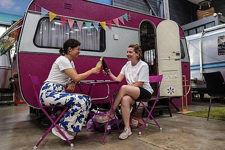Oliver Berg/dpa | Die beiden Französinnen genießen einen Abend in Bonn in entspannter Camping-Atmosphäre in der Halle des Basecamp.