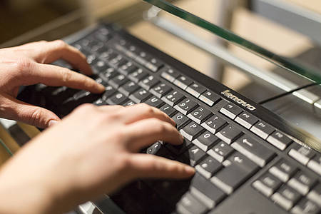Finger tippen auf schwarzer Tastatur