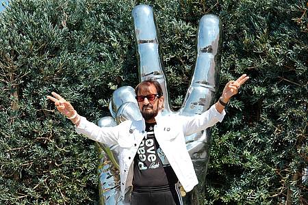 Chris Pizzello/Invision/dpa | Ringo Starr vor der von ihm gestalteten «Peace and Love»-Statue in seiner Wahlheimat Los Angeles. (Archivfoto) 