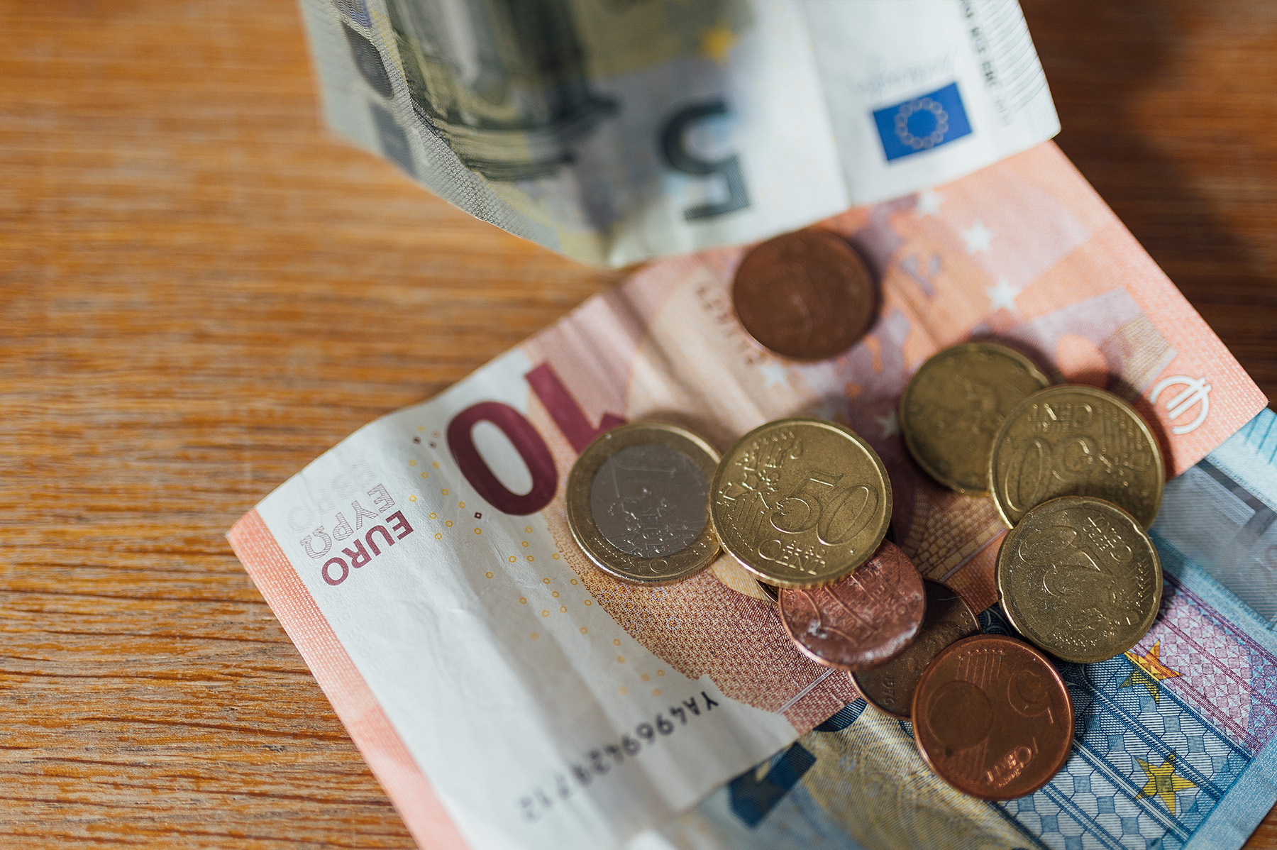 Geldscheine und Münzen liegen auf dem Tisch