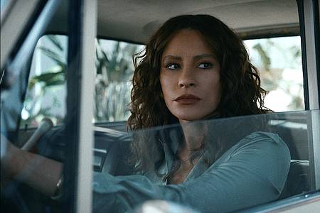 Sofia Vergara als Griselda Blanco auf Netflix schaut angespannt aus ihrem Autofenster.