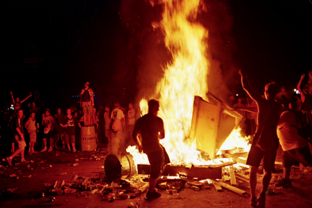 Menschen tanzen vor einem großen Feuer