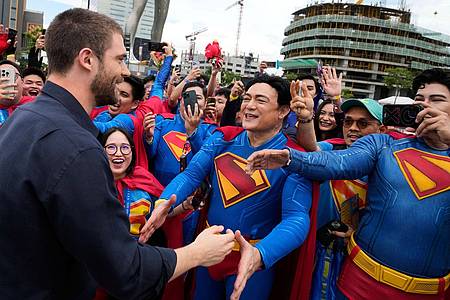 Aaron Favila/AP/dpa | Schauspieler und Superman-Star David Corenswet (l) begrüßt Fans während der ersten Station der Superman World Tour.