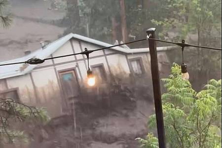 Kaitlyn Carpenter/via AP/dpa | In Ruidoso wird ein ganzes Haus von den Wassermassen mitgerissen. 