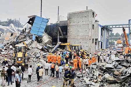 Uncredited/AP/dpa | Rettungskräfte suchen nach einer Explosion und einem Brand in einer Pharmafabrik in einem Industriegebiet in der Nähe von Hyderabad nach Überlebenden. (Foto Archiv)