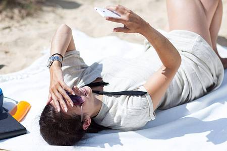 Christin Klose/dpa-tmn | Hot out there: Damit das Smartphone bei Hitze keinen Schaden nimmt, legt man es besser in den Schatten.