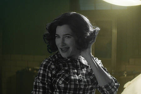 Die Hexe Agatha in schwarz weißem 60's-Look grinst - Agatha All Along auf Disney+.