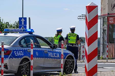 Patrick Pleul/dpa | Polnische Polizistinnen stehen am deutsch-polnischen Grenzübergang Stadtbrücke zwischen Frankfurt (Oder) und Slubice.