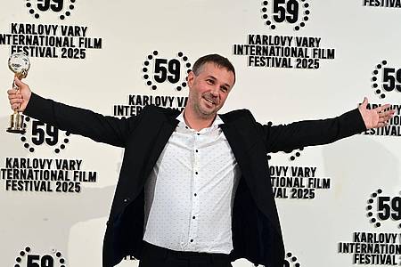 Slavomír Kube?/CTK/dpa | Der slowakische Regisseur Miro Remo posiert mit seiner Auszeichnung in der Hand. Miro gewann den Hauptpreis des 59. Karlsbader Filmfestivals.