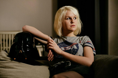 Hannah Schürkamp sitzt auf einem Sofa und schaut zur Seite