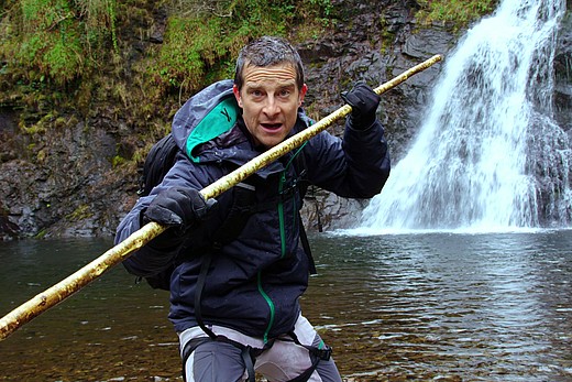 Bear Grylls posiert vor einem Wasserfall