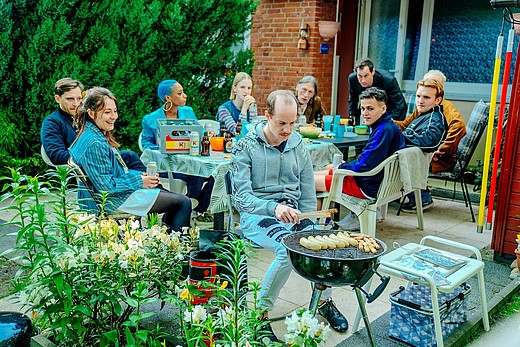 Mehrere Discounter-Mitarbeitende auf einer Terrasse beim Grillen