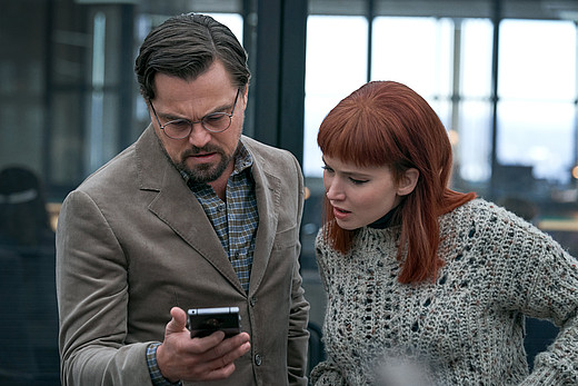 Die Protagonisten starren sorgenvoll auf ein Smartphone