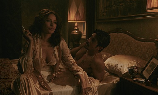 Sofia Vergara als Griselda Blanco auf Netflix sitzt mit ihrem Liebhaber im Bett und raucht.