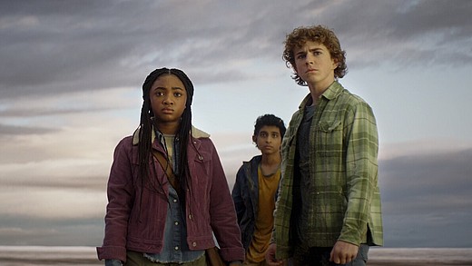 Percy, Annabeth und Rover aus der Disney+ Serie Percy Jackson stehen vor grauem Himmel und schauen angespannt in die Ferne.
