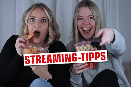 Zwei Frauen mit Popcorn, Chips und Fernbedienung