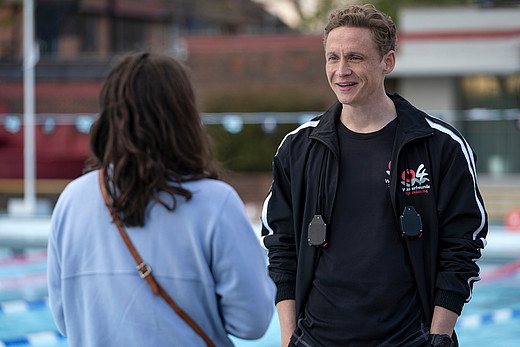 Junge Frau unterhält sich mit Schwimmtrainer Matthias Schweighöfer