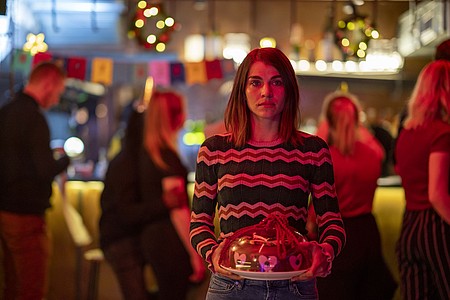Hauptprotagonistin Johanne steht mit einem Geburtstagskuchen auf einer Party.