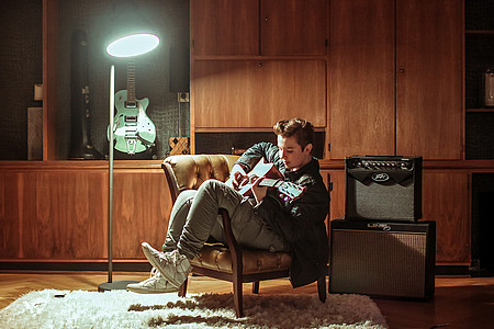 Ben Schafmeister mit Gitarre im Sessel